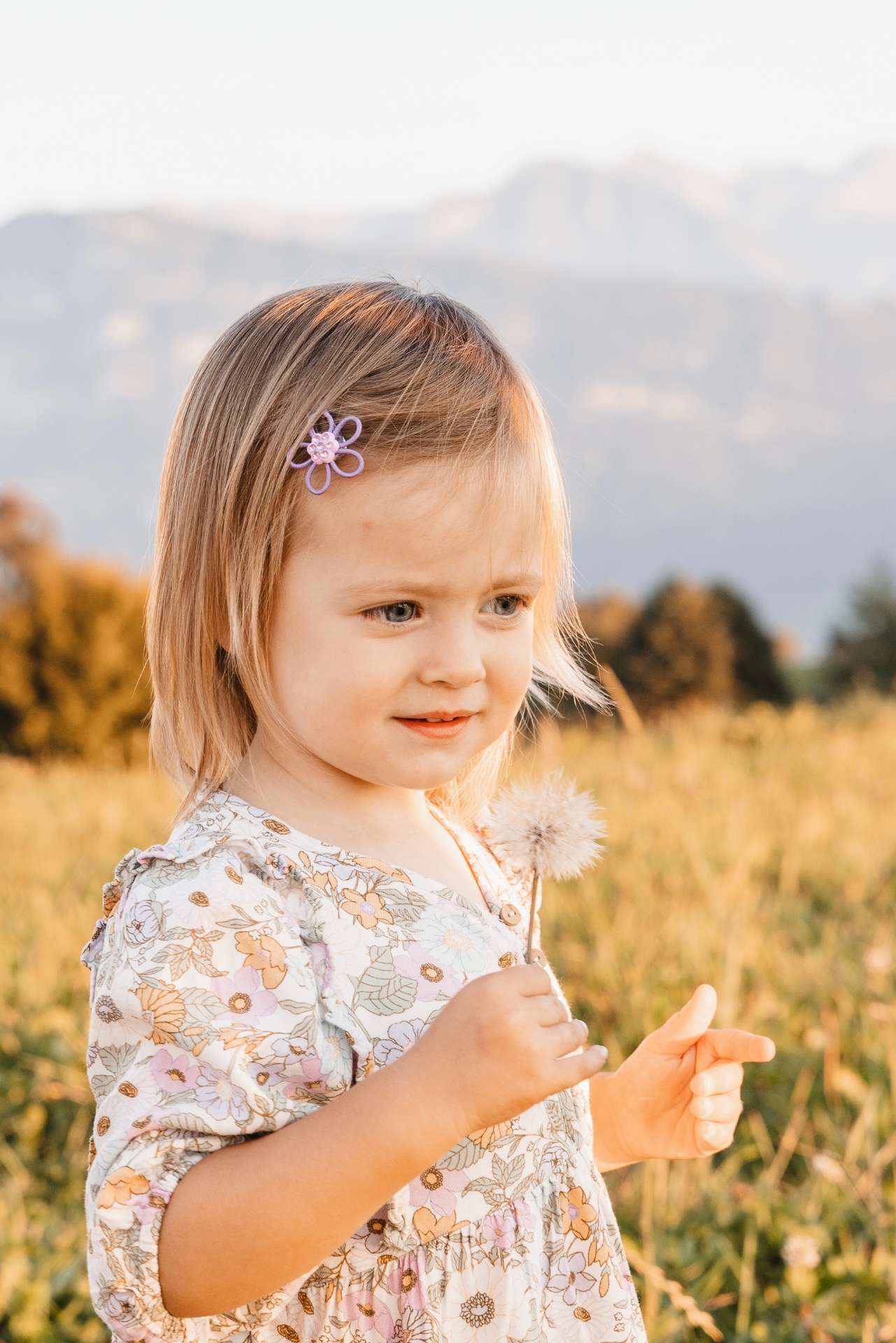 Mädchen mit Pusteblume vor Bergpanorama